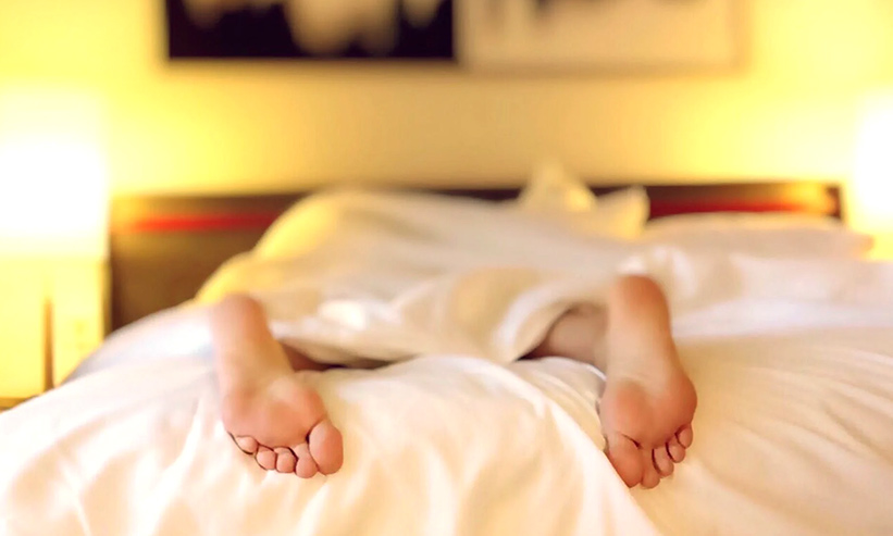 ベッドで寝ている女性の足の裏