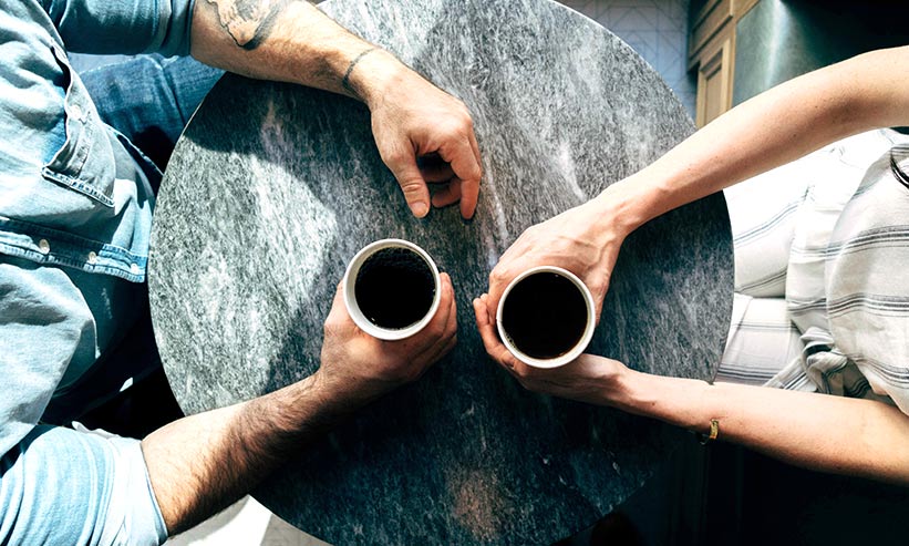 カフェでコーヒーを飲んでいるカップル