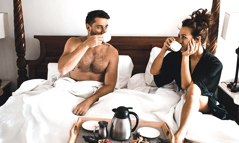 ベッドで朝食をとるカップル