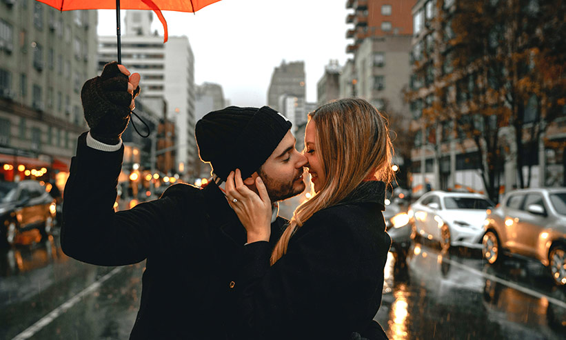 傘をさしながらキスをするカップル