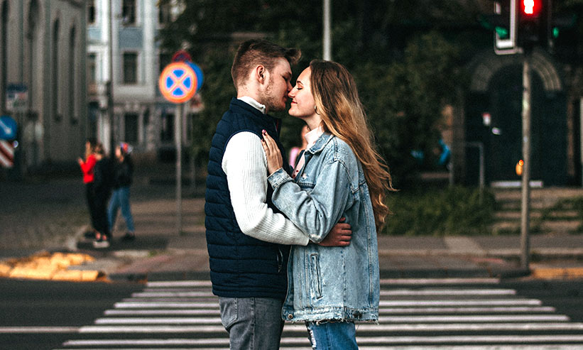 横断歩道の前でキスをしているカップル
