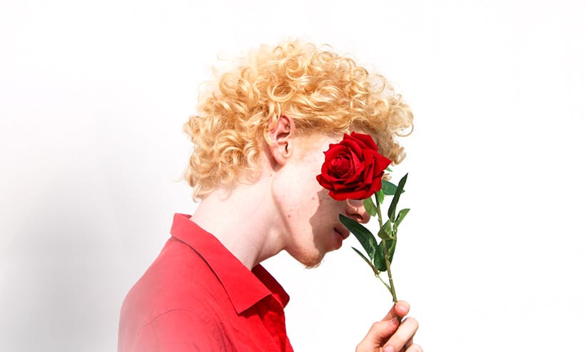 赤いバラを持つ男性