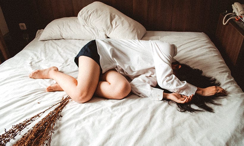 ベッドに顔をうずめ横たわっている女性