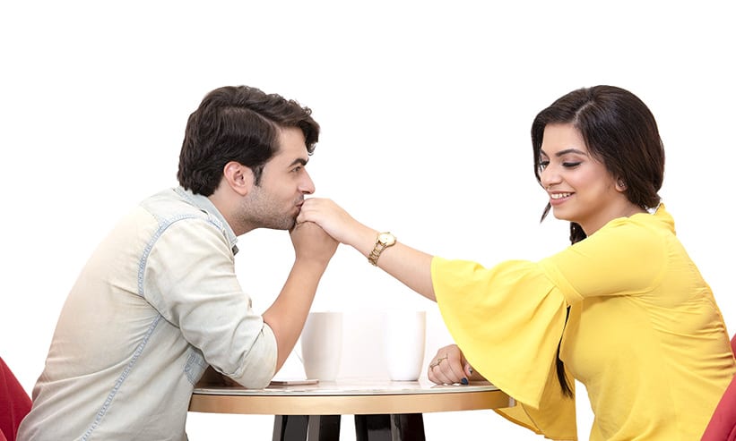 カフェで女性の手にキスをする男性