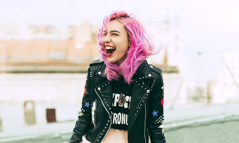 爆笑するピンク髪の女性