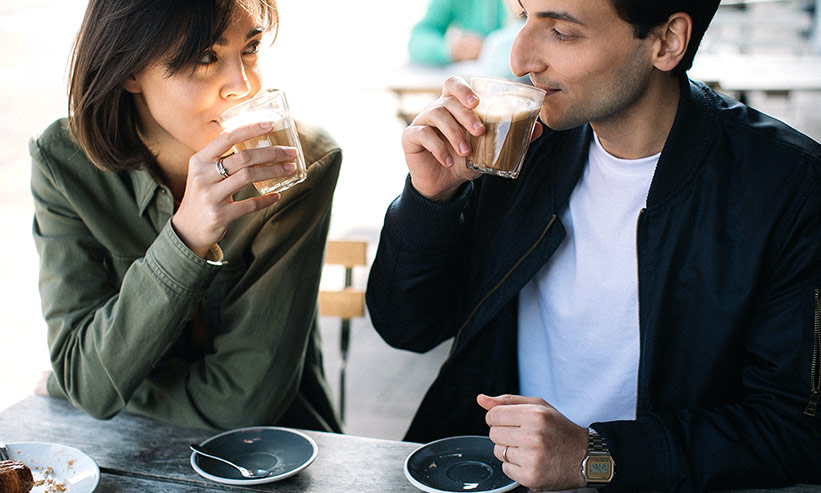 カフェで見つめあいながらコーヒーを飲むカップル